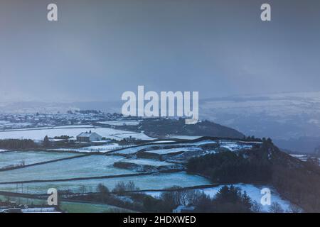 Durante la notte la neve e frequenti docce di neve hanno fatto per un inverno tetro mattina a Queensbury, Yorkshire occidentale, una mattina di gennaio. Queensbury è un grande villaggio nel distretto metropolitano di Bradford, West Yorkshire, Inghilterra. Arroccato su un alto punto panoramico sopra Halifax, Clayton e Thornton e affacciato su Bradford stesso, Queensbury è una delle più alte parrocchie in Inghilterra, con belle viste oltre la conurbazione West Yorkshire alle colline del Brontë Country e Yorkshire Dales a nord e nord ovest. Foto Stock