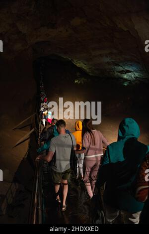 5 luglio 2018 Nuova Athos, Abkhazia: Gruppo di turisti cammina attraverso il ponte sospeso in una grotta enorme. Escursione per turisti. Immagine editoriale Foto Stock