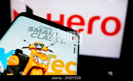 Telefono cellulare con pagina web della società automobilistica indiana Hero MotoCorp Limited sullo schermo di fronte al logo. Mettere a fuoco sulla parte superiore sinistra del display del telefono. Foto Stock