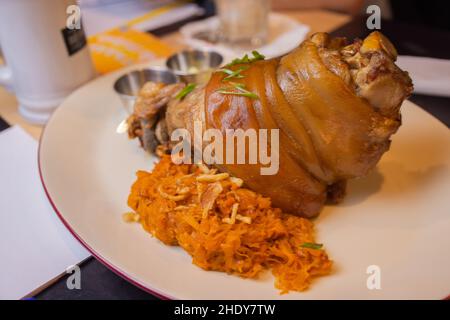 Arrosto di maiale eisbein fuso a snodo con brasato di Cavoli lessi e senape sul tagliere di legno Foto Stock