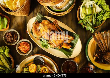 Ayam Goreng. Pollo fritto indonesiano servito con pasta di peperoncino, verdure e riso al vapore Foto Stock
