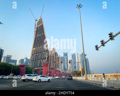 Doha, Qatar – 3 ottobre 2019: Paesaggio urbano e skyscapers del centro in costruzione con automobili e semaforo rosso contro il cielo blu Foto Stock