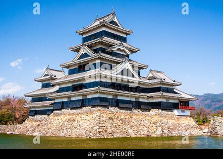 Il mantenimento e il fossato del monumento turistico castello Matsumoto in Giappone in una giornata di sole in primavera con cielo blu chiaro sfondo. Foto Stock