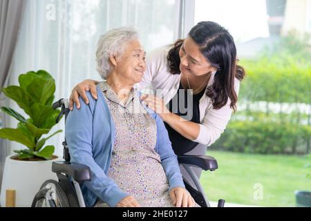 La figlia del caregiver aiuta la donna anziana anziana asiatica o anziana della donna seduta sulla sedia a rotelle. Foto Stock