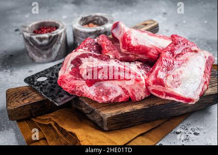 Manzo costolette di vitello kalbi, carne cruda su tavola macellaio in legno. Sfondo grigio. Vista dall'alto Foto Stock