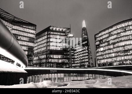 Splendida foto in bianco e nero di edifici in vetro di Londra con luci dal Potters Fields Park nel Regno Unito Foto Stock