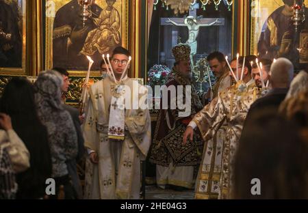 Un sacerdote conduce la messa alla chiesa greco-ortodossa di San Porphyrios. La maggior parte dei credenti ortodossi festeggia il Natale il 7 gennaio. Le chiese in Romania, Bulgaria, Cipro e Grecia lo segnano il 25 dicembre insieme ad altre denominazioni cristiane. (Foto di Ahmed Zakot / SOPA Images/Sipa USA) Foto Stock