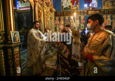 Un sacerdote conduce la messa alla chiesa greco-ortodossa di San Porphyrios. La maggior parte dei credenti ortodossi festeggia il Natale il 7 gennaio. Le chiese in Romania, Bulgaria, Cipro e Grecia lo segnano il 25 dicembre insieme ad altre denominazioni cristiane. (Foto di Ahmed Zakot / SOPA Images/Sipa USA) Foto Stock