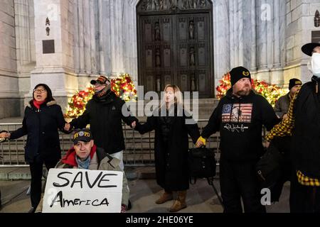 New York, New York, Stati Uniti. 6th Jan 2022. Un piccolo gruppo di sostenitori di Trump si riuniscono di fronte alla Cattedrale di San Patrizio per la veglia in occasione dell'anniversario dell'insurrezione, sono stati confrontati da un piccolo gruppo di membri Uniti contro il razzismo e il fascismo-NYC. Gli agenti di polizia separarono rapidamente due gruppi per prevenire scontri fisici. I membri di due gruppi gridarono l'uno all'altro per circa un'ora e dopo che si disperse. I sostenitori di Trump hanno acceso i cnadle e cantato l’inno nazionale, così come le preghiere. (Credit Image: © Lev Radin/Pacific Press via ZUMA Press Wire) Foto Stock