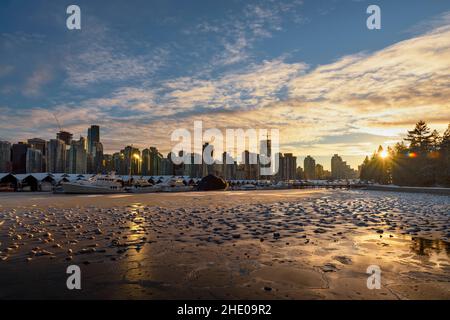 la superficie del mare coperto di ghiaccio, che riflette la luce del sole serale, yacht e navi sul molo sullo sfondo di buildin Foto Stock