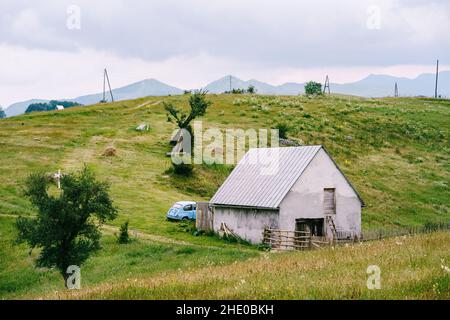 Casa con una recinzione in legno picket nelle Highlands del Montenegro settentrionale Foto Stock