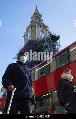 07/01/2022 - un anziano che indossa una maschera passa davanti alla famosa Elizabeth Tower di Londra, nel centro di Londra, come dice il segretario alla salute Sajid Javid Foto Stock