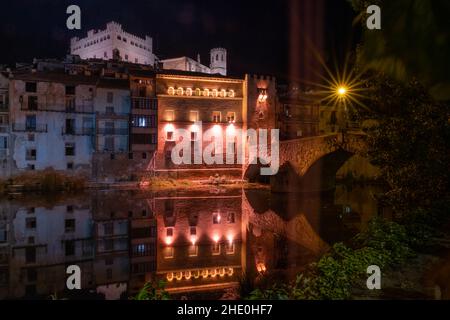 Il passaggio del fiume Matarraña attraverso il ponte medievale di Valderrobres nella regione di Matarraña a Teruel fotografato di notte con il riv Foto Stock