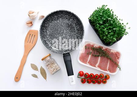 Padella in marmo nero con prodotti su sfondo grigio, vista dall'alto Foto Stock