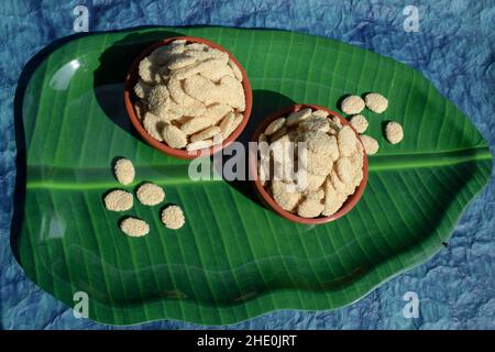 Gattino di zucchero di semi di Rewri o Sesamo, alimento ittico indiano di Sankranti. Rewri gajak servito in terrena ciotola su foglia di banana Foto Stock