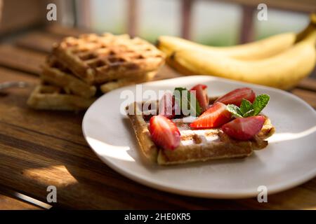 Waffle con fragole, banane e miele. Foto Stock