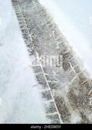 Primo piano dei cingoli degli pneumatici nella neve con sporcizia Foto Stock