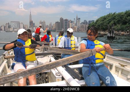 Gli adolescenti del negozio di apprendisti dell'East River partecipano al programma esploratori marittimi visto qui a canottaggio sull'East River a NYC su un concerto di Bantry Bay. Foto Stock