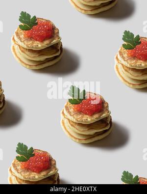 Modello verticale con pancake con caviale rosso su sfondo bianco. Stampe, motivi. Foto Stock