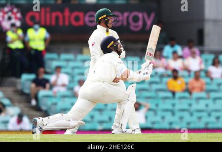 Il Jack Leach dell'Inghilterra colpisce un colpo per essere catturato dal Pat Cummins dell'Australia durante il quarto giorno del test delle ceneri al Sydney Cricket Ground, Sydney. Data foto: Sabato 8 gennaio 2022. Foto Stock