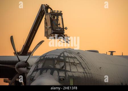 Un Airman assegnato al 374th Aircraft Maintenance Squadron de-ices a C-130J Super Hercules assegnato al 36th Airlift Squadron alla Yokota Air base, Giappone, 7 gennaio 2022. Lo sbrinatore utilizza acqua riscaldata miscelata con glicole per scongelare il ghiaccio e impedire la formazione di ghiaccio futuro sull'aereo. (STATI UNITI Air Force foto di Yasuo Osakabe) Foto Stock