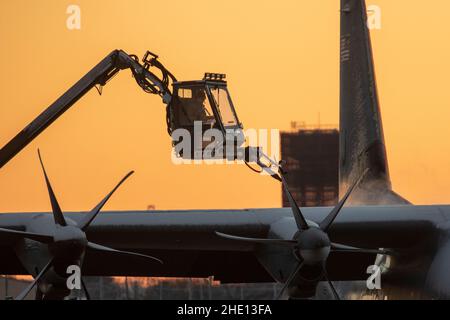 Un Airman assegnato al 374th Aircraft Maintenance Squadron de-ices a C-130J Super Hercules assegnato al 36th Airlift Squadron alla Yokota Air base, Giappone, 7 gennaio 2022. Lo sbrinatore utilizza acqua riscaldata miscelata con glicole per scongelare il ghiaccio e impedire la formazione di ghiaccio futuro sull'aereo. (STATI UNITI Air Force foto di Yasuo Osakabe) Foto Stock