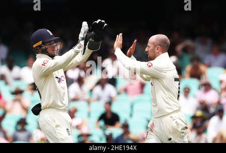 Il Jack Leach (a destra) dell'Inghilterra celebra con Ollie Pope dopo che ha preso il wicket di Steve Smith dell'Australia durante il giorno quattro della quarta prova delle ceneri al campo di Cricket di Sydney. Data foto: Sabato 8 gennaio 2022. Foto Stock