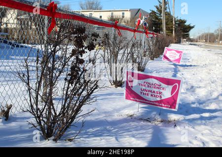 Segui i cartelli Science Unmask The Kids nella neve in una giornata di sole a Morton Grove, Illinois Foto Stock