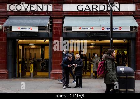 Londra, Regno Unito. 07th Jan 2022. Due turisti sono visti guardando sui loro telefoni fuori dalla stazione della metropolitana di Covert Garden. Credit: SOPA Images Limited/Alamy Live News Foto Stock
