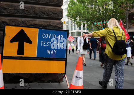Melbourne, Australia. 8th gennaio 2022, Melbourne, Australia. Un manifestante anti anti-vax passa davanti a un sito di test COVID presso il Municipio di Melbourne, puntando il pollice verso il basso. Credit: Jay Kogler/Alamy Live News Foto Stock