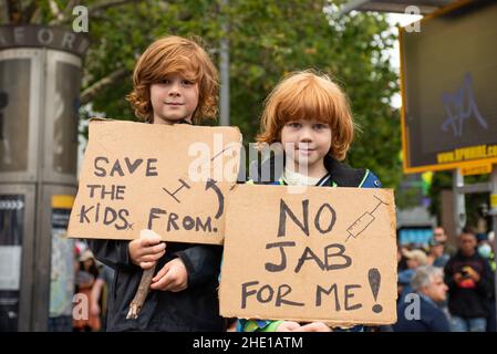 Melbourne, Australia. 8th gennaio 2022, Melbourne, Australia. Due bambini posano con i segni anti-vaccinazione ad una marcia dei capretti contro i vaccini. Credit: Jay Kogler/Alamy Live News Foto Stock