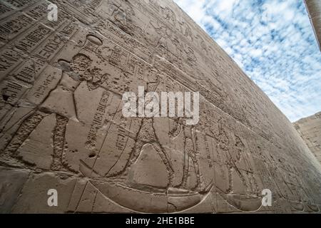 Le pareti del tempio di Edfu sono coperte da geroglifici e sculture in rilievo che rendono questo uno dei siti archeologici più famosi in Egitto. Foto Stock