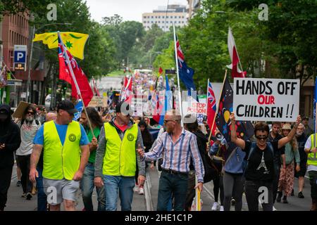 Melbourne, Australia. 8th gennaio 2022, Melbourne, Australia. Un manifestante anti anti-vax che porta un livello di spirito conversa con 'peacemakers' al Kids March for Freedom. Credit: Jay Kogler/Alamy Live News Foto Stock