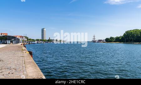 Travemuende, Schleswig-Holstein, Germania - 17 giugno 2020: Vista sul fiume trave con il terminal delle navi da crociera sulla sinistra e il vecchio faro in Foto Stock