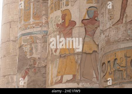 Antiche sculture in rilievo egiziane che sono rimaste ben conservate e dipinte sulle colonne nella sala Hypotyle a Karnak, Egitto. Foto Stock