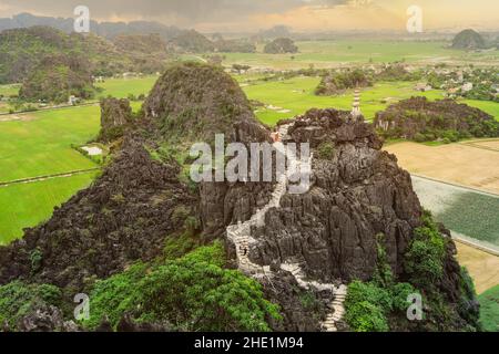 Rocce calcaree e pagoda in cima alla montagna dal punto di vista del Tempio di Hang Mua in una giornata di pioggia. Ninh Binh, Vietnam Foto Stock
