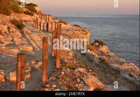 Sentiero costiero sterrato con pali di legno, scogliere di arenaria sulla costa atlantica in Algarve Portogallo meridionale. Foto Stock