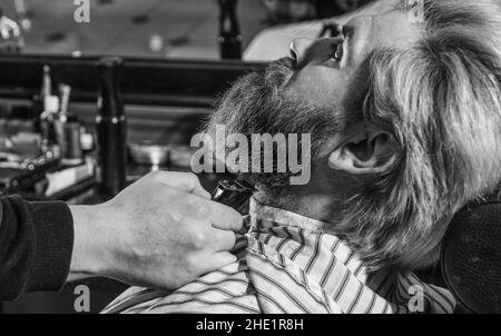 Mantenere la forma della barba. Migliora la tua esperienza di taglio dei capelli. Capelli del viso. Fai crescere barba e baffi. Uomo al barbiere. Salone parrucchiere Foto Stock