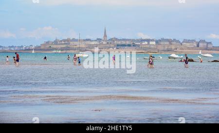 Saint Malo, Francia - 13 luglio 2017: Persone che camminano nella baia di St Malo, Bretagna, Francia con la bassa marea. St Malo, una città storica sulla costa atlantica, h Foto Stock