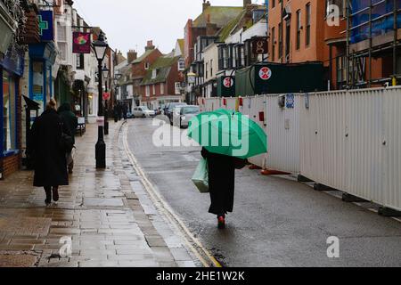 Segale, East Sussex, Regno Unito. 08 Jan 2022. Tempo UK: I visitatori dell'antica città di Rye camminano lungo la strada principale tenendo ombrelloni come più pesante pioggia è previsto più tardi. Photo Credit: Paul Lawrenson /Alamy Live News Foto Stock