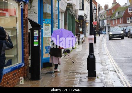 Segale, East Sussex, Regno Unito. 08 Jan 2022. Tempo UK: I visitatori dell'antica città di Rye camminano lungo la strada principale tenendo ombrelloni come più pesante pioggia è previsto più tardi. Photo Credit: Paul Lawrenson /Alamy Live News Foto Stock