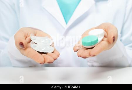 Medico oftalmologo che tiene in mano lenti a contatto di un giorno e lenti a contatto riutilizzabili. Scelta tra tipi di lenti a contatto . miopia e occhi Foto Stock