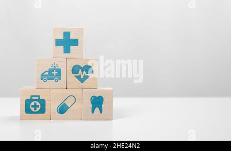 Icona medica su piramide di cubi. Medicina e assicurazione sanitaria concetti. Blocchi di legno con icone di vari tipi di assicurazione, icone mediche med Foto Stock