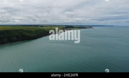 Immagine aerea della costa gallese e della scogliera a Llannon, Cerediaion. Cielo blu e mare, spiaggia di ciottoli, sentiero costiero. Foto Stock