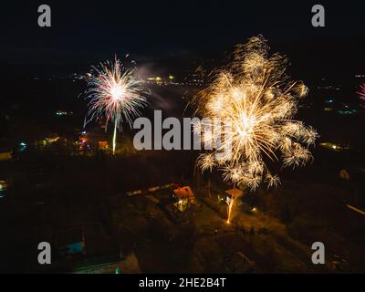 Vista aerea dei fuochi d'artificio in montagna alla fine della stagione invernale. Divertimento con fuochi d'artificio la vigilia di Capodanno. Arte colorata Foto di alta qualità Foto Stock