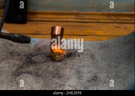 Saldatura in rame, processo di installazione e saldatura di tubi in rame al camino di riscaldamento. Foto Stock