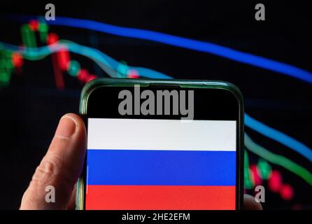 Cina. 09th Dic 2021. In questa illustrazione della foto, la bandiera della Federazione Russa è visualizzata su uno smartphone con un grafico dell'indice delle borse economiche sullo sfondo. (Foto di Budrul Chukrut/SOPA Images/Sipa USA) Credit: Sipa USA/Alamy Live News Foto Stock