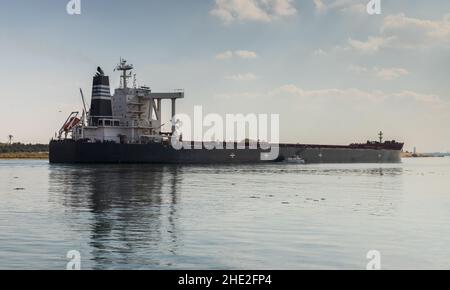 Nave da carico con scafo nero passa il canale di Suez, Ismailia, Egitto Foto Stock