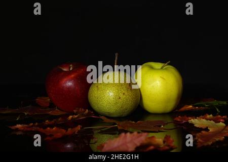 Le mele e le pere mature si trovano sul tavolo Foto Stock