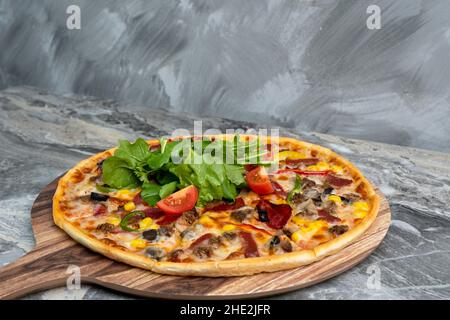 Deliziosa pizza servita su piatto di legno. Vista dall'alto Foto Stock